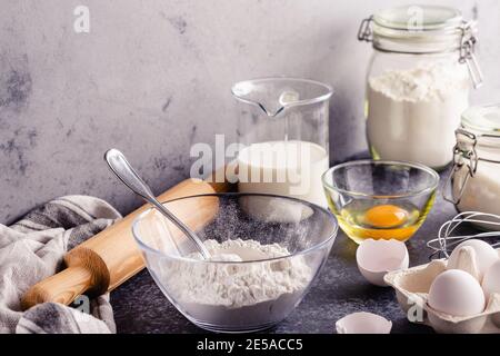 Background. Kochzutaten für Teig, Eier, Mehl, Zucker, Milch. Stockfoto