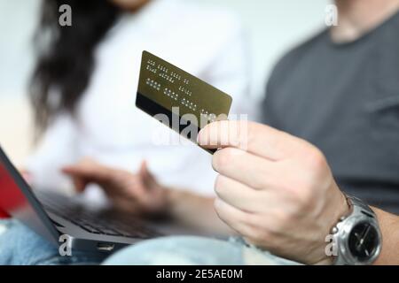 Mann und Frau sitzen am Laptop mit Bankkarte In den Händen Nahaufnahme Stockfoto