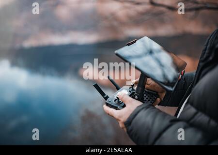 Mann, der eine Drohne mit einer Fernbedienung betreibt. Stockfoto