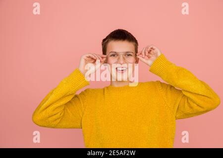 Brillen tragen. Kaukasische Mädchen Porträt auf Koralle rosa Studio-Hintergrund mit Copyspace für Anzeige. Schönes Modell in Pullover. Konzept der menschlichen Emotionen, Gesichtsausdruck, Verkauf, Werbung, Mode. Stockfoto