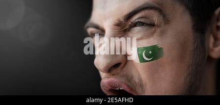 Ein schreiender Mann mit dem Bild des pakistanischen Nationales Flagge auf seinem Gesicht Stockfoto