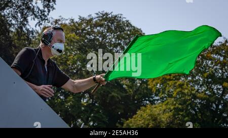 Ein Schuss einer grünen Flagge, die während eines Rennens gewellt wird. Stockfoto