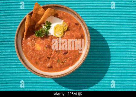 HAUSGEMACHTE VEGETARISCHE CHILI MIT MAIS NACHO CHIPS, SAURE SAHNE. PETERSILIE UND JALAPENO PFEFFER Stockfoto