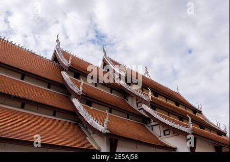 Die Steingut-Fliese auf dem Dach der Thai-Kirche, verziert mit dem Schlangenstuck im traditionellen nordthailändischen Stil, Seitenansicht mit der Kopie Stockfoto