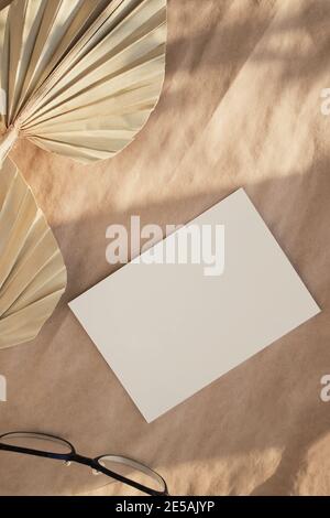 Minimale Standzeit für Schreibwaren. Trockene Palmblätter auf Bastelpapier. Stockfoto