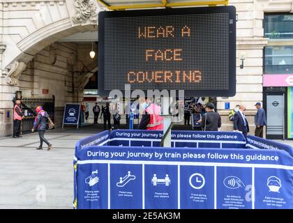 Covid Pandemie Warnschild, Gesichtsbedeckung oder Maske auf öffentlichen Verkehrsmitteln zu tragen, Victoria Bahnhof, London, Großbritannien Stockfoto