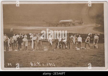 Soldaten im Bedfordshire Imperial Yeomanry (BIY) werden nach den Übungen im Jahr 1913 gewaschen. Der Waschtisch ist auf einem Feld aufgestellt und im Hintergrund ist ein mit Dampfmaschine betriebenes Stück Landmaschinen zu sehen. Mehrere Soldaten waschen oder schleppen sich selbst, während andere dabeistehen und die Kamera betrachten. Das Foto wurde im Jahr vor Ausbruch des Ersten Weltkriegs in oder um Thurning, in der Nähe von Oundle, Northamptonshire, aufgenommen. Stockfoto