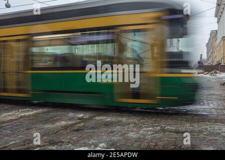 Finnland, Helsinki. 26. Januar 2021 Grüne Straßenbahn in Bewegung. Hochwertige Fotos Stockfoto