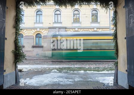 Finnland, Helsinki. 26. Januar 2021 Grüne Straßenbahn in Bewegung. Hochwertige Fotos Stockfoto