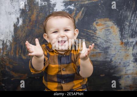 Sehr glücklich und lachend Baby Junge elf Monate alt im Freien im Winter in einer Innenstadt Einstellung. Stockfoto