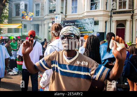 Kerl mit einer Bandana, die in Notting auf der Straße tanzt Bergkarneval Stockfoto