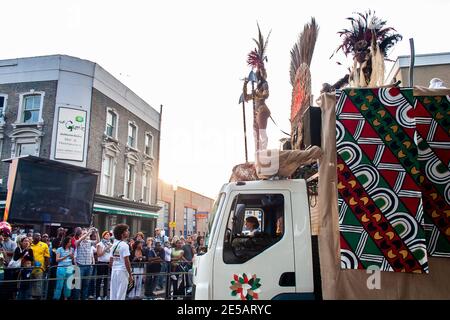 Riesiger Karnevalswagen mit Tänzern in Kostümen bewegt sich durch die Straßen in Notting Hill Carnival Stockfoto