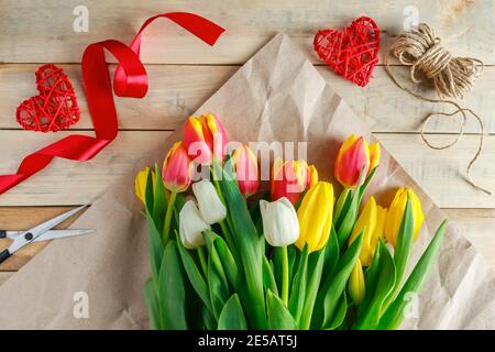 Geschenkbouquet von Tulpen in Bastelpapier. Valentinstag-Konzept. Stockfoto