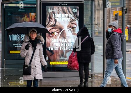 Edinburgh, Schottland, Großbritannien. 27. Januar 2021. Mitglieder der Öffentlichkeit gehen heute an der neuen Regierung vorbei Covid-19 Gesundheitswarnplakate auf der Princes Street in Edinburgh. Iain Masterton/Alamy Live News Stockfoto