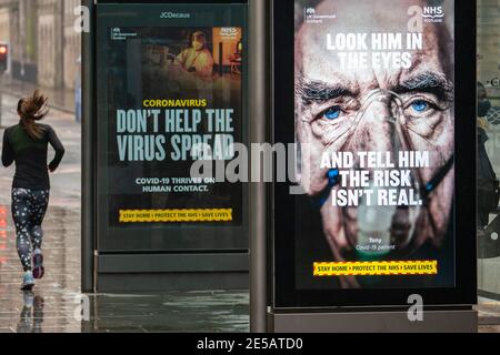 Edinburgh, Schottland, Großbritannien. 27. Januar 2021. Mitglieder der Öffentlichkeit gehen heute an der neuen Regierung vorbei Covid-19 Gesundheitswarnplakate auf der Princes Street in Edinburgh. Iain Masterton/Alamy Live News Stockfoto