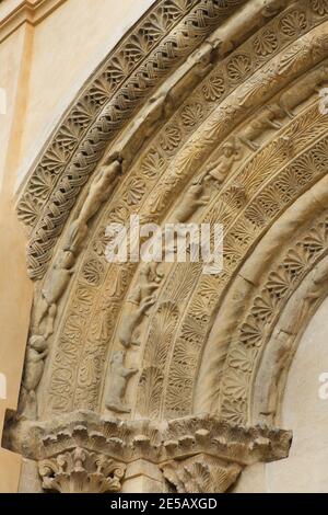 Hunde und Wölfe, die auf dem romanischen Portal aus dem letzten Viertel des 12. Jahrhunderts an der Südfassade der Kirche des Heiligen Prokopius (Kostel svatého Prokopa) in Záboří nad Labem in Mittelböhmen, Tschechische Republik, abgebildet sind. Stockfoto