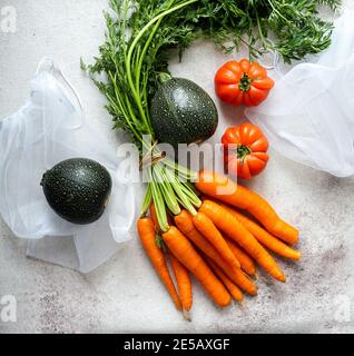 Zero Waste Food Storage Eco Bag mit Karotte, Tomaten, Top View, umweltfreundliche Beutel für Gemüse, Öko-Verpackung Stockfoto