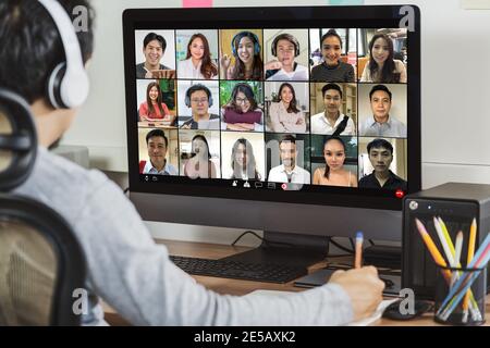Rückansicht des asiatischen Geschäftsmannes arbeiten und Online-Meeting über Videokonferenz mit Kollegen und Team-Building, wenn Covid-19 Pandemie, Coronavirus aus Stockfoto