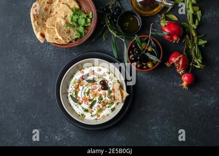 iranisches oder arabisches Gericht, Joghurt labneh Ziegen Milchdip mit Taftbrot und Granatapfel Stockfoto