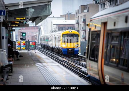 Ein Overground Zug nähert sich Haggerston Station an einem kalten verschneiten Tag. Stockfoto