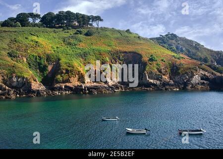 Blaues Wasser und schroffen Klippen im Hafen Saints Bay, Guernsey. Stockfoto