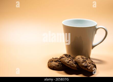 Nahaufnahme eines weißen Krug Milch und eines Haufen Dunkler Schokoladenkekse Stockfoto