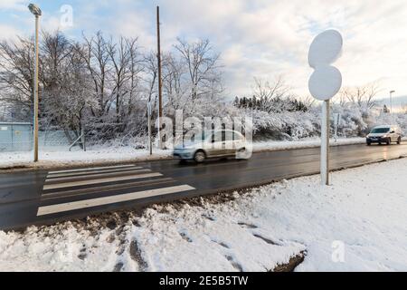 Verkehrsschilder mit Schnee bedeckt neben der Straße im Winter, Sopron, Ungarn Stockfoto