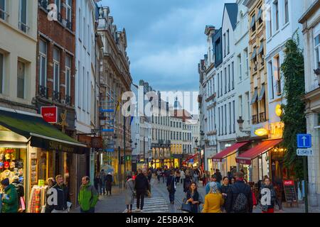 BRÜSSEL, BELGIEN - 06. OKTOBER 2019: Menschenmenge, die in der Dämmerung an der Einkaufsstraße der Altstadt von Brüssel spazieren Stockfoto