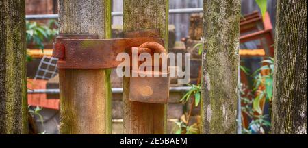 Rostiger Vorhängeschloss auf Holztor Stockfoto