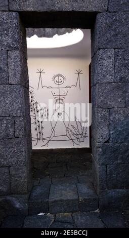 Ungewöhnlich beleuchtete öffentliche Toilette Schild führt zu einem männlichen W. Lanzarote, Kanarische Inseln, Spanien. Das Gebäude besteht aus Lavablöcken. Stockfoto