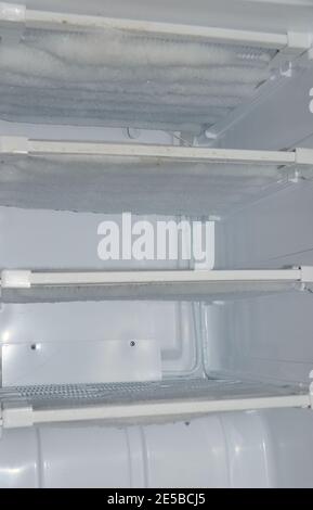Blick in einen leeren Kühlschrank, der zum Auftauen überfällig ist. Stockfoto