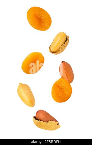 Herabfallende Erdnüsse und getrocknete Aprikosen isoliert auf weißem Hintergrund Stockfoto