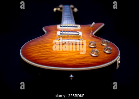 Niedriger Winkel der isolierten Vintage-E-Gitarre mit Sunburst Finish Auf schwarzem Hintergrund Stockfoto