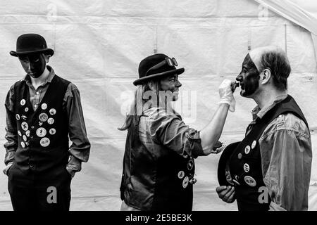 Eine Gruppe von Morris-Tänzern, die ihr Make-up vor dem Auftritt im Hartfield Village Fete, Hartfield, East Sussex, Großbritannien, anwenden. Stockfoto