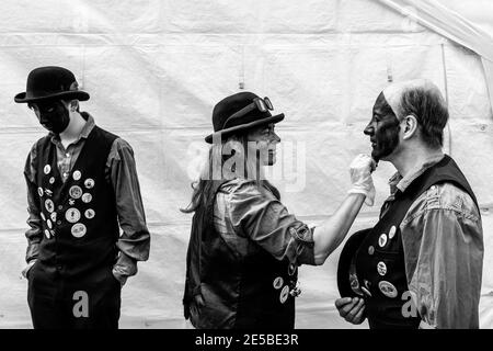 Eine Gruppe von Morris-Tänzern, die ihr Make-up vor dem Auftritt im Hartfield Village Fete, Hartfield, East Sussex, Großbritannien, anwenden. Stockfoto