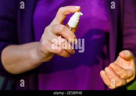 Nahaufnahme Frauen Hände halten Spray. Antibakterielles Spray für die Hände. Spray Desinfektionsmittel für die präventive Coronavirus-Ausbreitung. Stockfoto