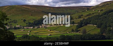 Weite Panoramablick auf das Dorf und Heuwiesen von Gunnerside, Swaledale, Yorkshire Dales National Park. Stockfoto