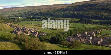 Weite Panoramablick auf das Dorf und Heuwiesen von Gunnerside, Swaledale, Yorkshire Dales National Park, in Abendlicht. Stockfoto