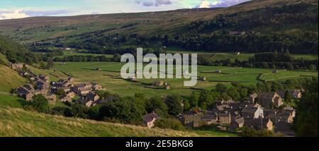 Weite Panoramablick auf das Dorf und Heuwiesen von Gunnerside, Swaledale, Yorkshire Dales National Park, in Abendlicht. Stockfoto