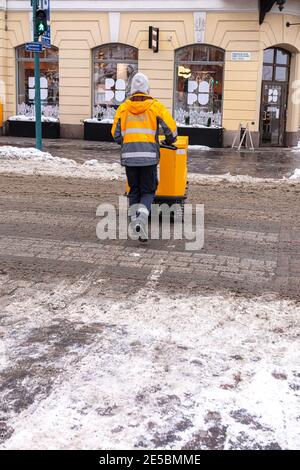 Finnland, Helsinki. 26. Januar 2021 EIN männlicher Postbote in Overalls liefert Post. Hochwertige Fotos Stockfoto