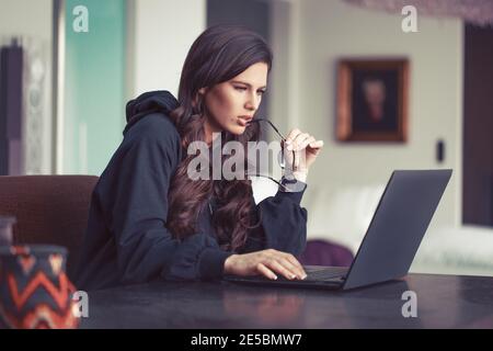 Junge intelligente kaukasische Frau Lesen Dokument im Home Office Stockfoto