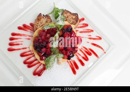 Gebratenes Fleisch und Pfannkuchen mit süßer Obstmarmelade. Diese befindet sich auf einer weißen Platte. Nahaufnahme. Stockfoto