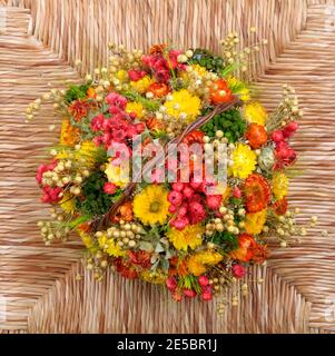 Bunte getrocknete Blumenstrauß im Korb auf gewebter Oberfläche. Draufsicht auf floralem Hintergrund Stockfoto