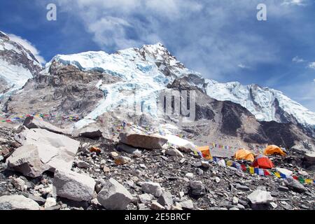 Blick vom Everest-Basislager auf die westliche Felswand des Nuptse-Gipfels mit Zelten und Gebetsfahnen, Sagarmatha-Nationalpark, nepal, Himalaya Stockfoto