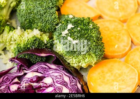 Frisches Gemüse Süßkartoffel, Brokkoli, lila Kohl auf dem Backpapier. Gesunde Mahlzeit Stockfoto
