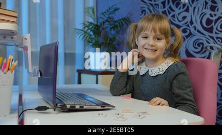 Online-Lernen, Fernunterricht, Unterricht zu Hause, Technologie für Kinder. Mädchen tun Schulprogramm Online-Hausaufgaben mit Lehrer, mit digitalen Laptop-Computer. Ausbildung während der Quarantäne des Coronavirus Stockfoto