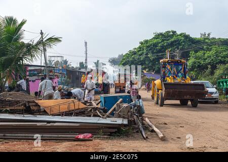 Nandakeshwar, Karnataka, Indien - 7. November 2013: Streetview zeigt Feldweg, wo Menschen durch recycelbare Trümmer sortieren, während Bulldozer dekoriert ist Stockfoto