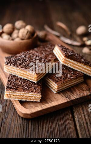 Hausgemachte süße Waffel mit Walnuss Toffee Füllung gefüllt und gekrönt Mit Schokoladenfrosting auf Holzhintergrund Stockfoto