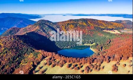 St. Ana See, Siebenbürgen, Rumänien. Atemberaubende Herbstlandschaft mit bunten Wald und idyllischen vulkanischen See ein beliebtes touristische und Reise destinati Stockfoto