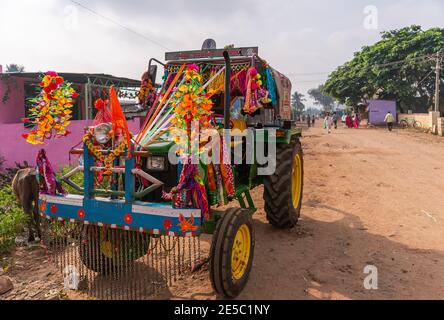 Nandakeshwar, Karnataka, Indien - 7. November 2013: Frontale Nahaufnahme des grünen Traktors auf Feldstraßensportarten mehrere Blumenleis für Diwali unter Silber s Stockfoto